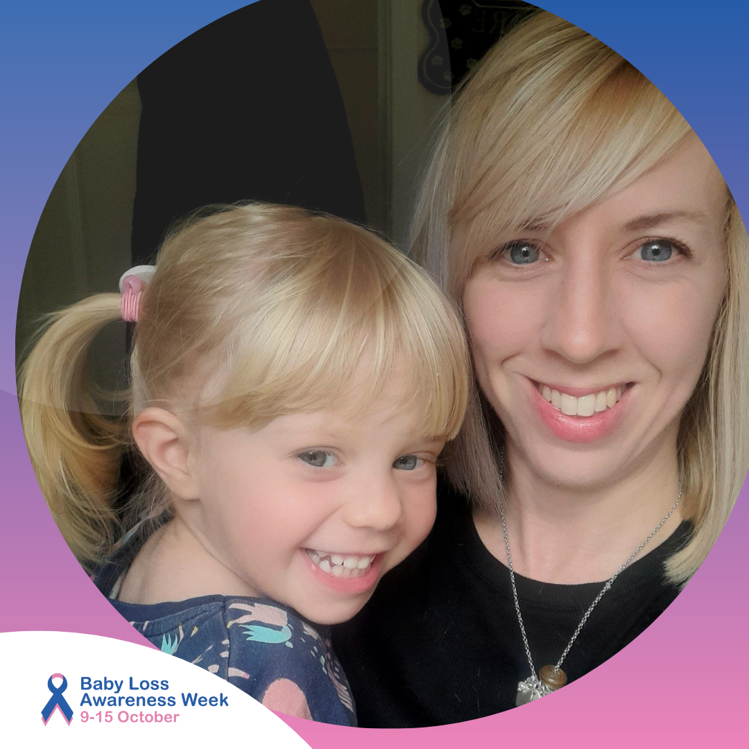 Joanne is taking a selfie-style photo with a little girl, they are both smiling.