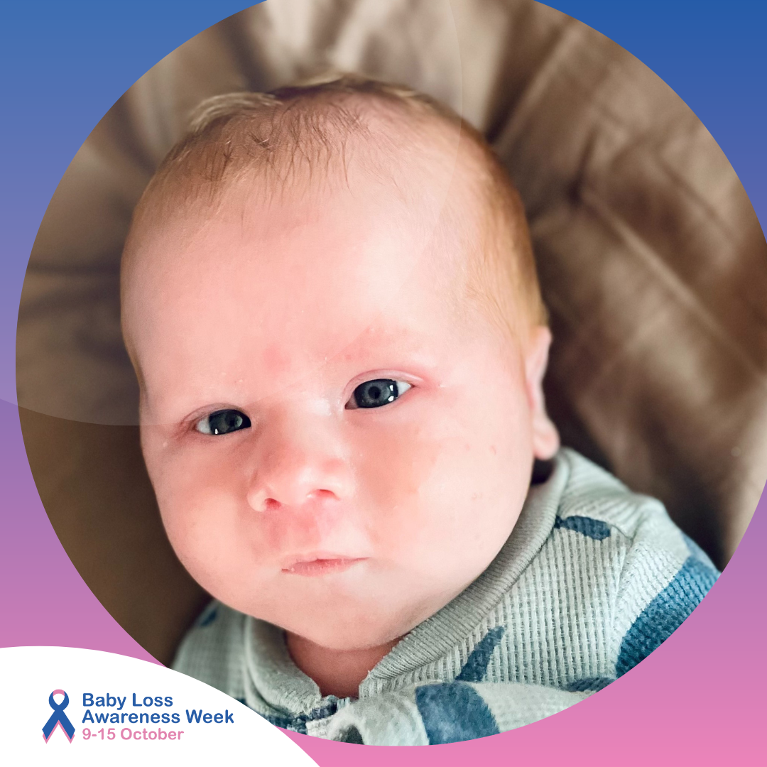 Jagger is laid down and is awake, with deep blue eyes and light hair.